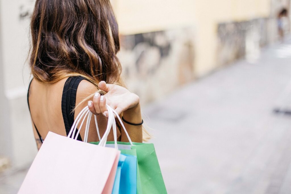 Persoon bij de kassa in de supermarkt met een volle boodschappenwagen, prijzen zichtbaar op scherm