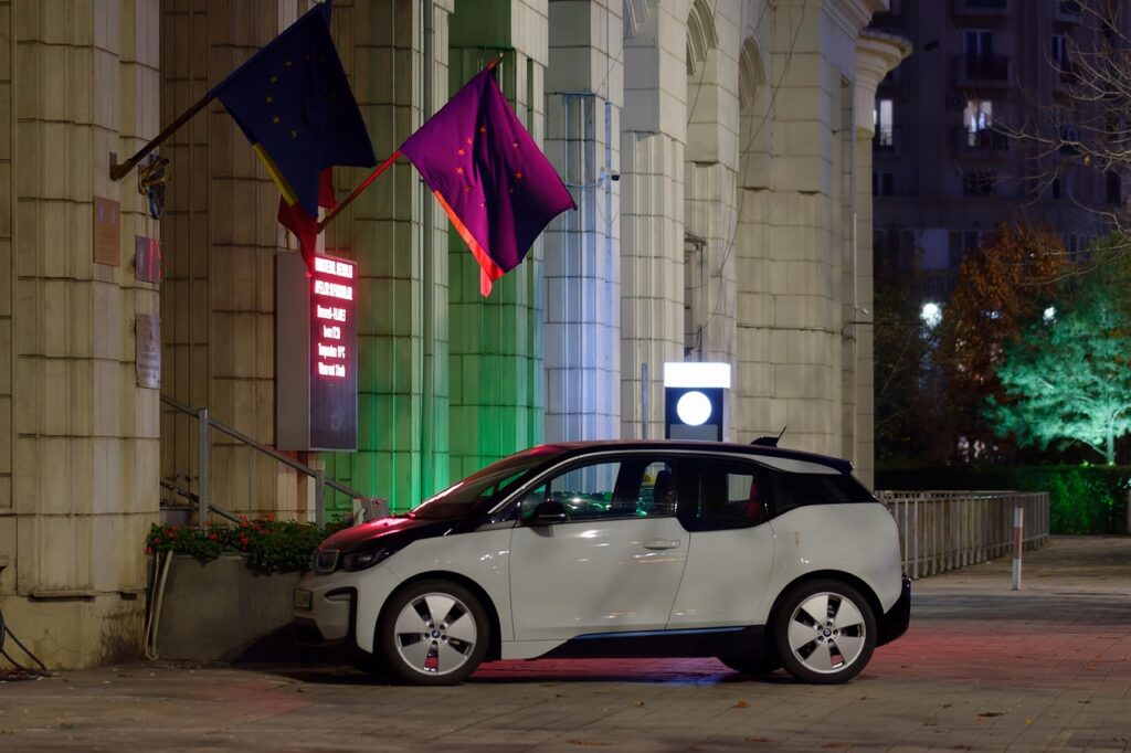 Werknemer bij een elektrische leaseauto op een bedrijventerrein