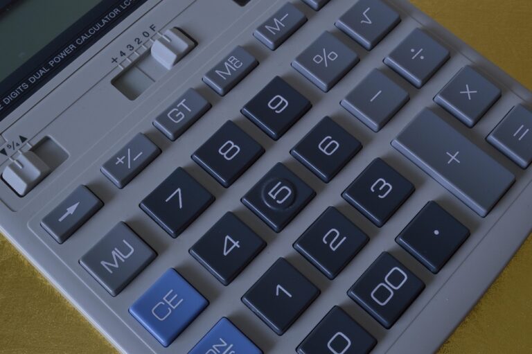Persoon die dropshipping kosten doorrekent op een laptop met rekenmachine naast zich
