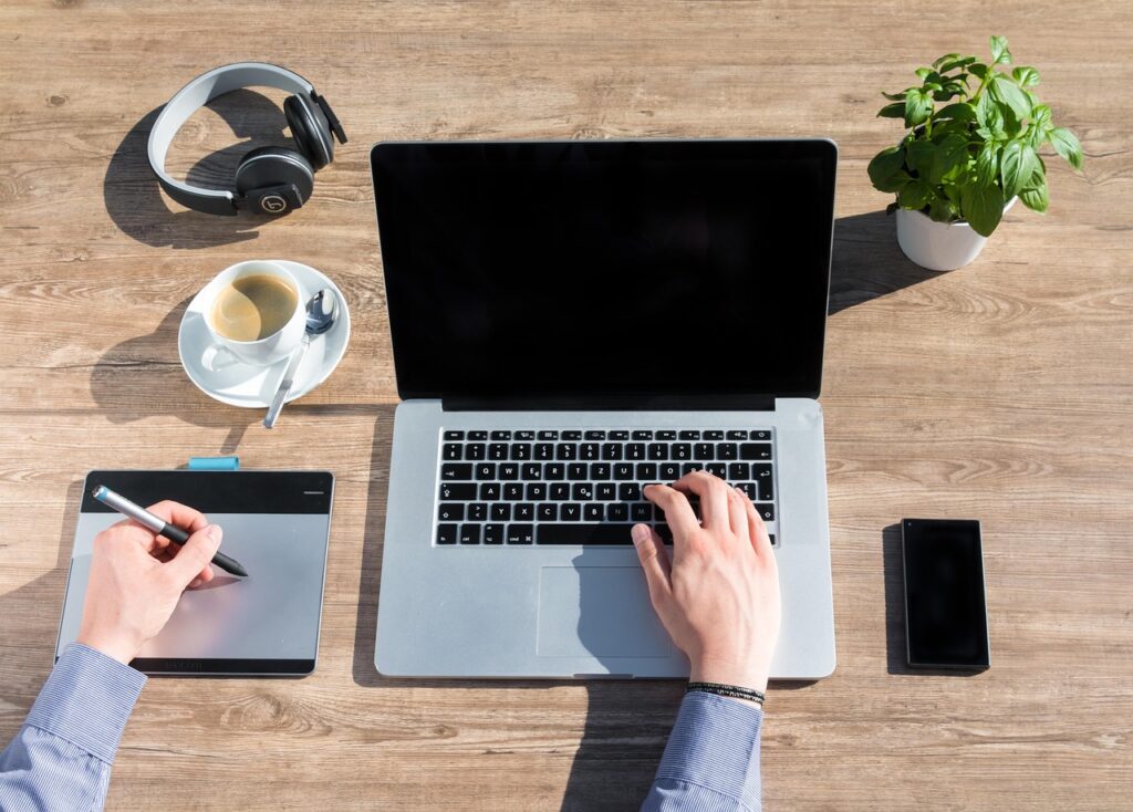 Zzp'er die achter een laptop werkt en financiële cijfers analyseert aan een bureau