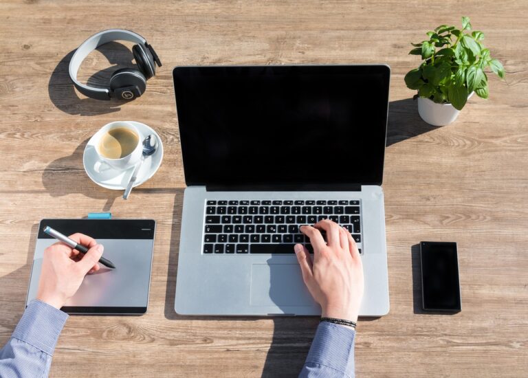 Zzp'er die achter een laptop werkt en financiële cijfers analyseert aan een bureau