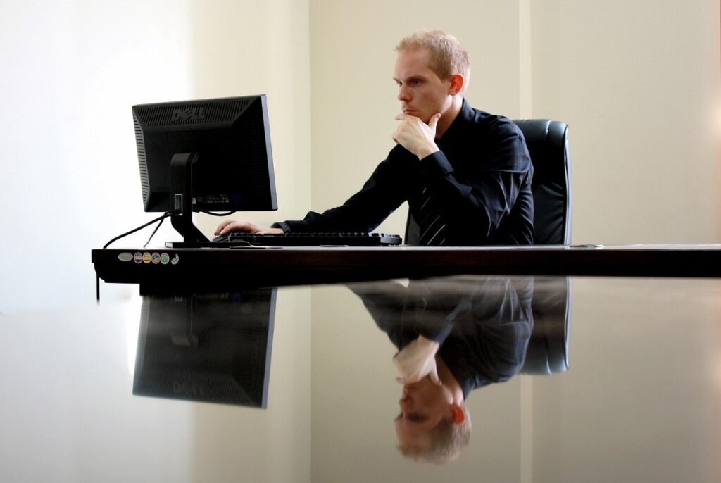 Ondernemer werkt geconcentreerd aan zijn bureau met een laptop en aantekeningen
