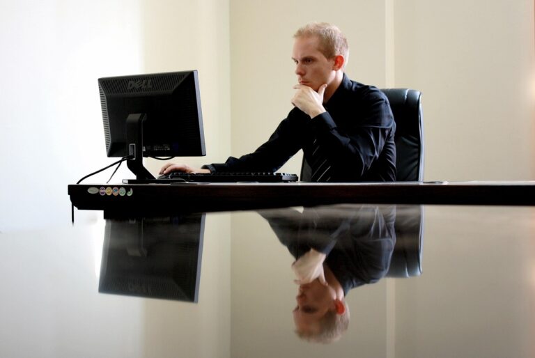 Ondernemer werkt geconcentreerd aan zijn bureau met een laptop en aantekeningen
