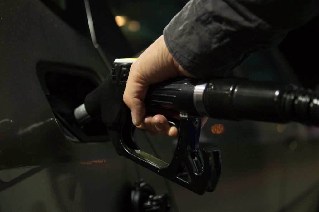 Automobilisten tanken bij een benzinestation vlak over de grens