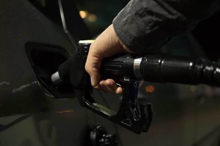 Automobilisten tanken bij een benzinestation vlak over de grens