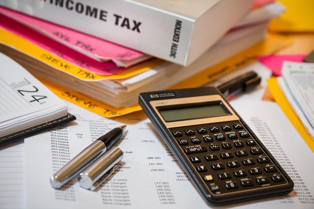 Calculator met belastingpapieren op een bureau voor een financiële berekening