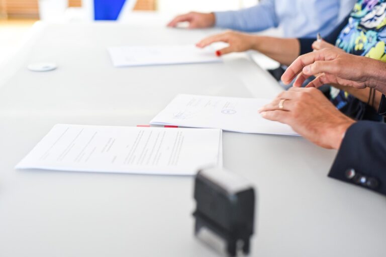 Twee ondernemers die een zakelijk contract doornemen aan een vergadertafel