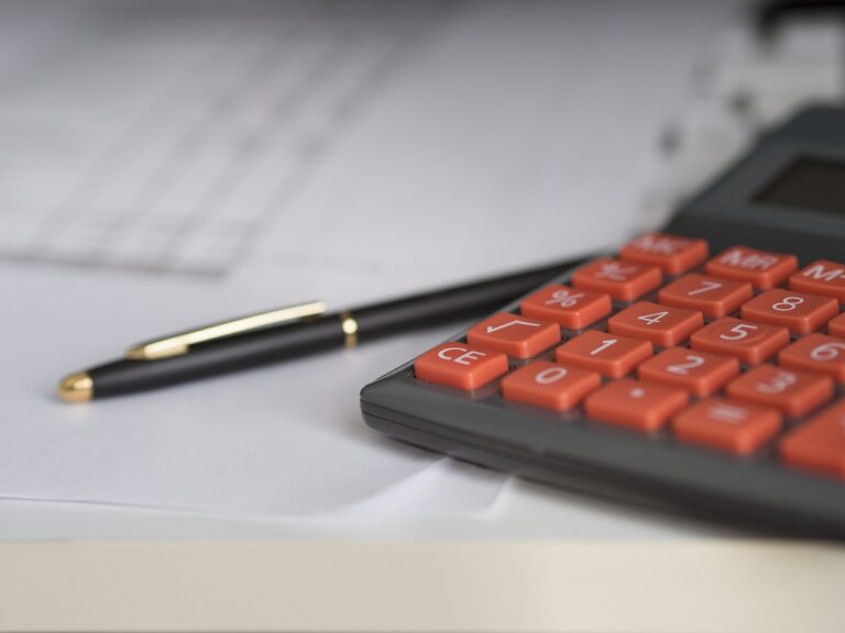MKB-ondernemer rekent aan bureau met calculator en facturen